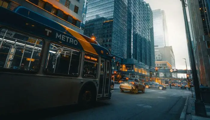 Ônibus transitando em uma rua de uma grande cidade