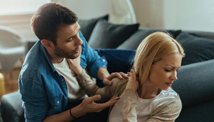 Mulher com rosto virado tenta afasta homem com a mão