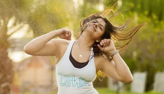 Bela garota com dançando zumba em um parque