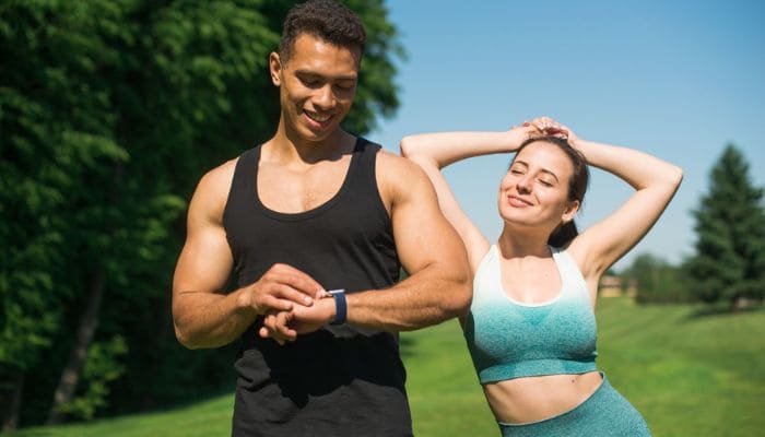 Homem e mulher com roupas de treino felizes no parque.