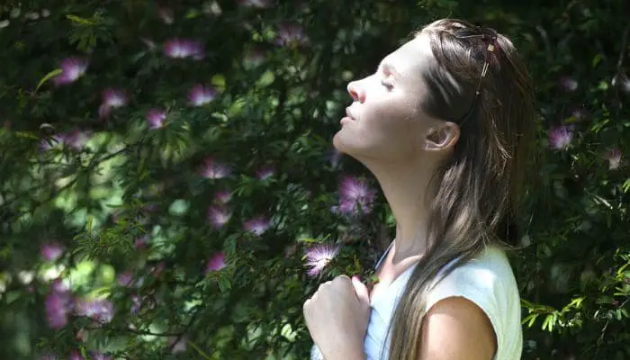 Mulher-de-olhos-fechados-respirando-e-praticando-atencao-plena