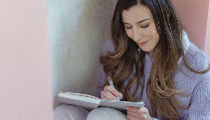 Mulher feliz fazendo anotações em um caderno