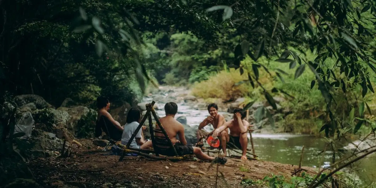 Banho no rio: Grupo de pessoas em roda de conversa às margens de um rio