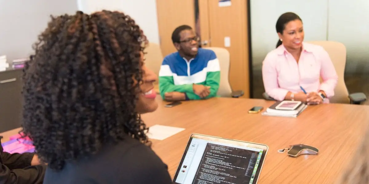 Desenvolvimento pessoal - Grupo de pessoas sorrindo em uma mesa de reuniões