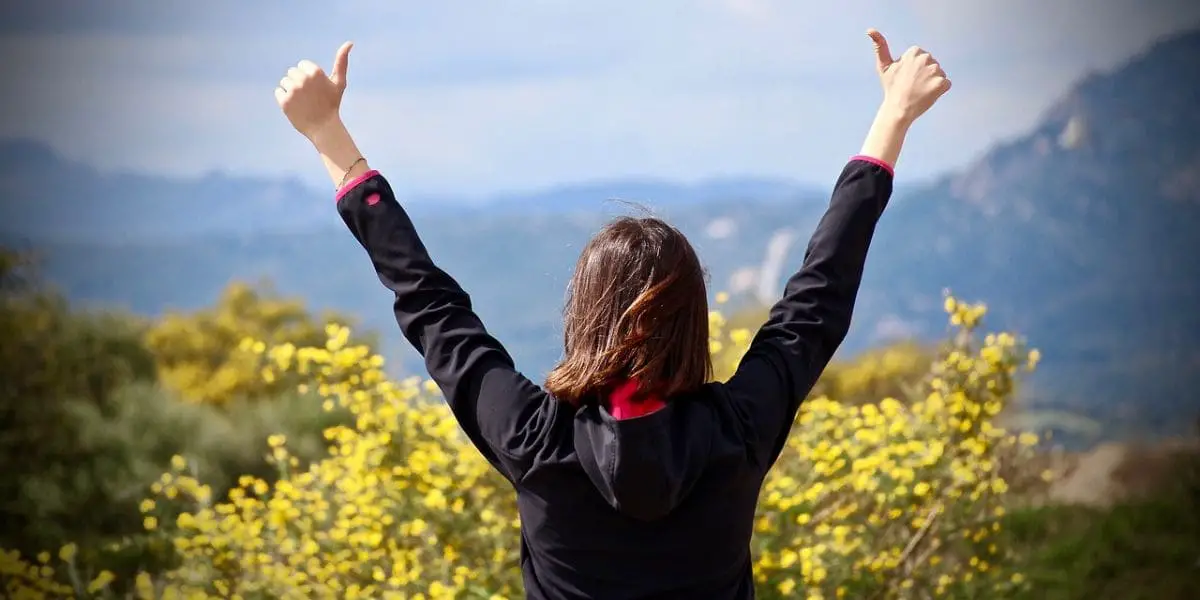 Pensamento positivo - Mulher de braços abertos em uma bela paisagem