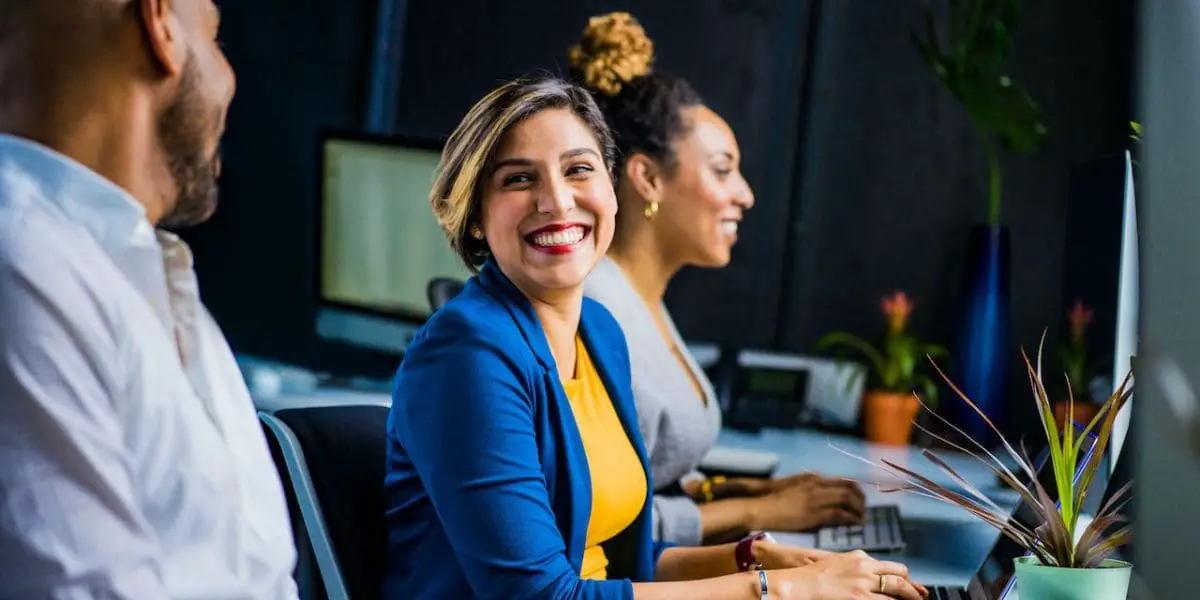 Cuidar das emoções no ambiente profissional: Pessoas alegres em grupo de trabalho